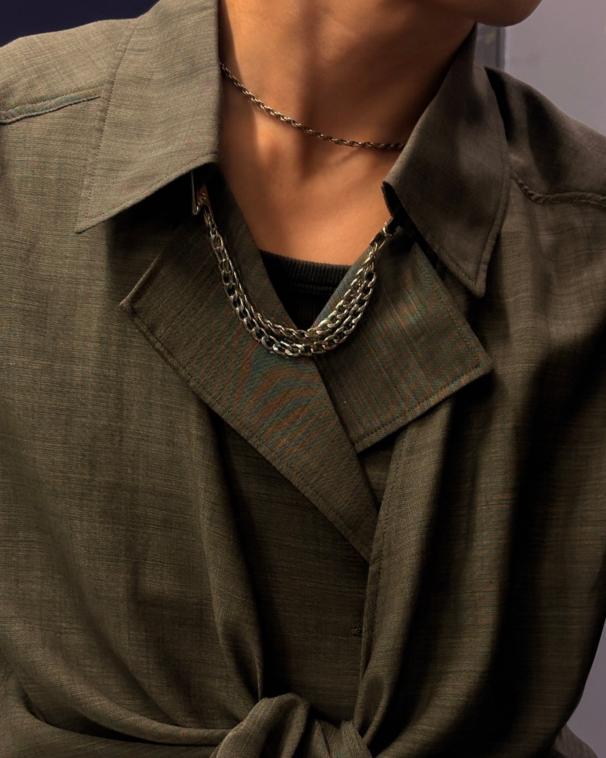 Person wearing a green jacket with a chain collar clip